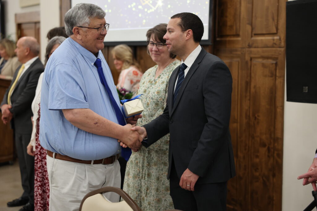 Andrew at Retiree Recognition Event Andrew shaking hands with a retiree during a recognition event.