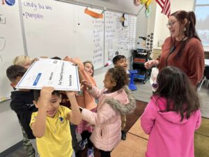 Supportive and Joyful Classroom Environment A teacher and young students celebrate together in a joyful classroom after receiving a grant.